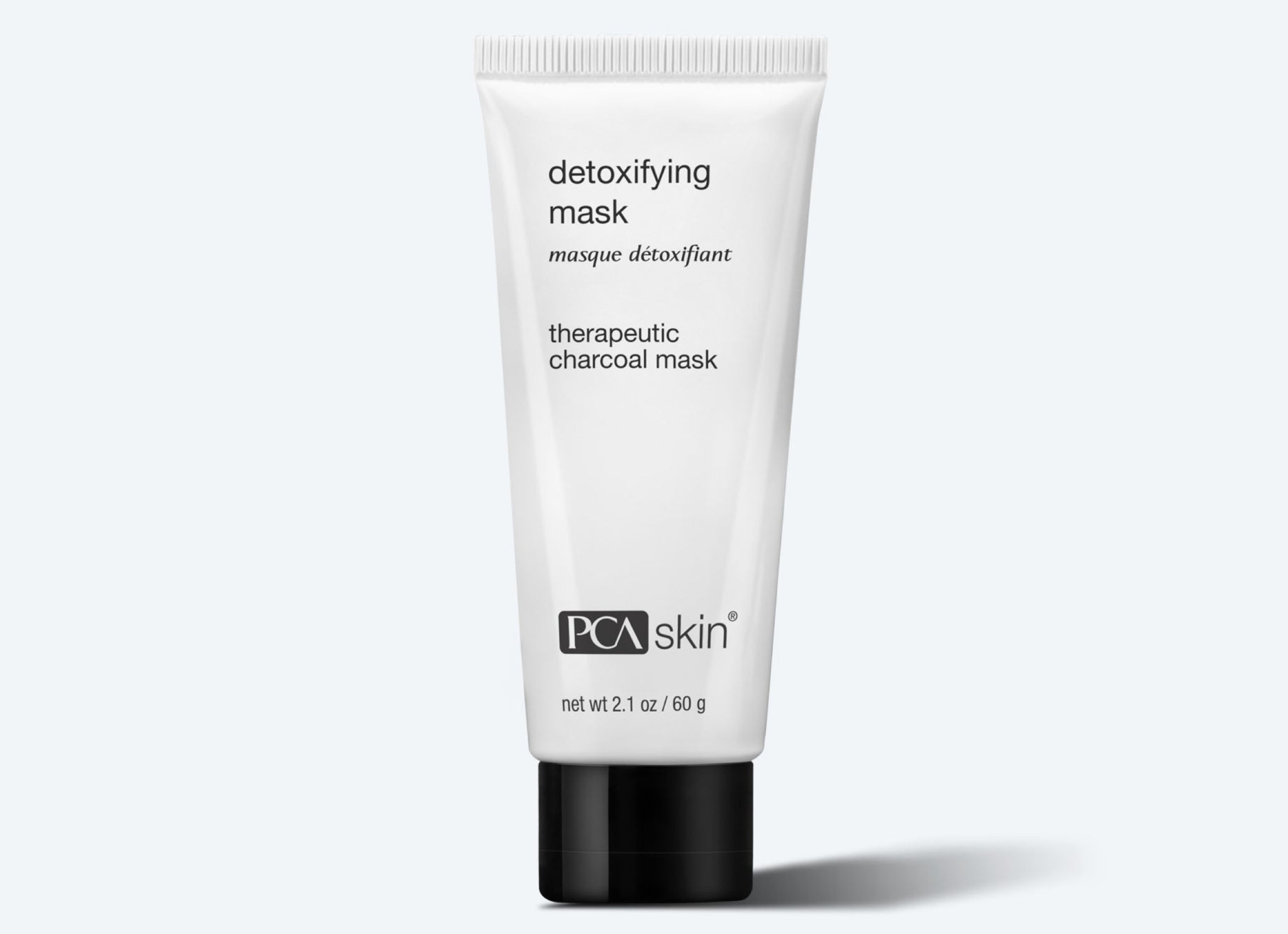 A white tube of PCA Skin Detoxifying Mask (2.1 oz/60 g) with a black cap is labeled "therapeutic charcoal mask" and shown against a light gray background.