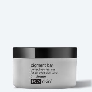 A white jar with a black lid labeled "pigment bar corrective cleanser for an even skin tone 01 cleanse" from PCA Skin sits on a light gray background—ideal prep before applying the Detoxifying Mask.
